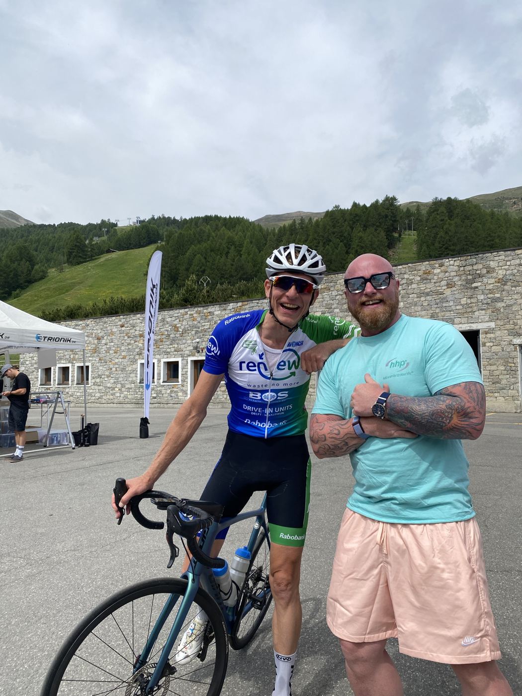 Olav Pirmajer mit einem Radprofi bei einem Rennen in den Alpen